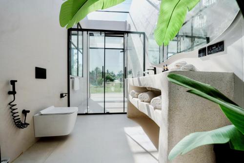 a bathroom with a toilet and a glass door at Casa Del Mare Ocean SeaView Villa with Private Pool in Zanzibar City