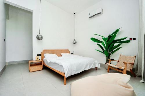 a bedroom with a bed and a chair and a plant at Casa Del Mare Ocean SeaView Villa with Private Pool in Zanzibar City