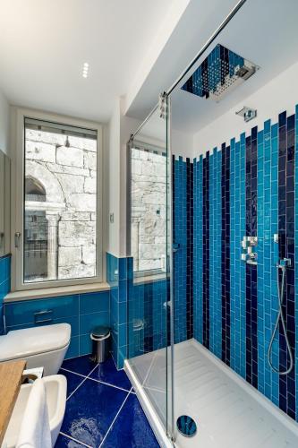 a bathroom with blue tiles and a shower at La Suite Del Cavaliere in Amalfi