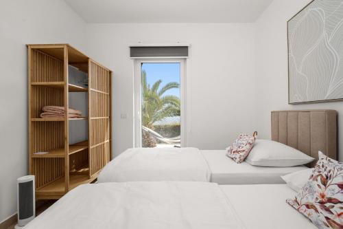 two beds in a white room with a window at Apartment Paradiso - Ravni in Labin