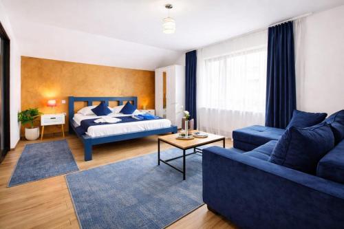 a living room with a bed and a blue couch at Residence by DANIA & PETRU in Târgu Ocna