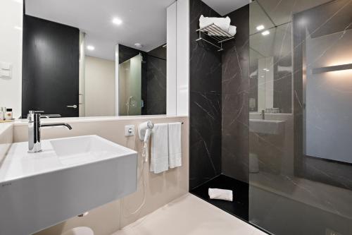a bathroom with a white sink and a shower at Axis Viana Business & SPA Hotel in Viana do Castelo