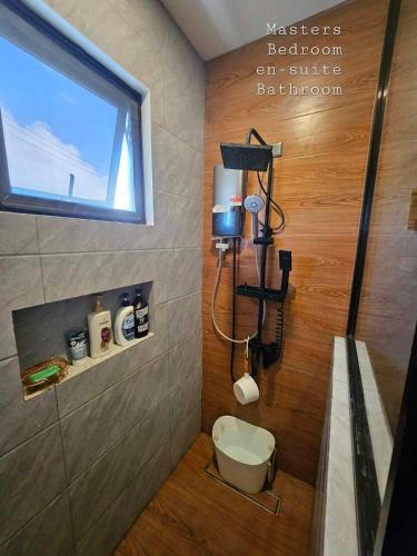 a bathroom with a toilet and a window at CASA CORAZON Spacious 4BR House Near Tagaytay for Wedding Prep Family Gatherings Reunions and Celebrations Pet Friendly and PWD Accessible in Dagatan