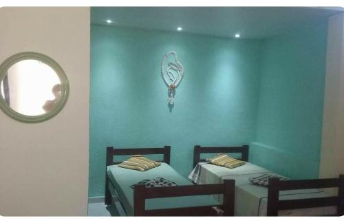 two beds in a room with a mirror on the wall at POUSADA GRACAS in Cachoeira Paulista