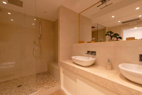 a bathroom with two sinks and a shower at Maison de Charme Taormina with private jacuzzi in Taormina
