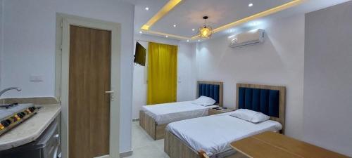 a hotel room with two beds and a kitchen at Egy property in 6th Of October