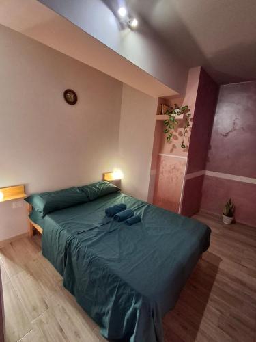 a bedroom with a bed with a green comforter at Nel borgo San Francesco in Montesarchio