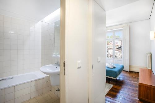 a bathroom with a sink and a tub and a toilet at HI Guimaraes - Pousada de Juventude in Guimarães