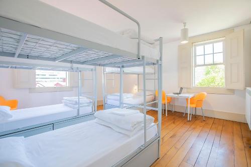 a room with two bunk beds and a table at HI Guimaraes - Pousada de Juventude in Guimarães