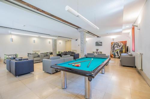 a gaming room with a pool table and couches at HI Guimaraes - Pousada de Juventude in Guimarães