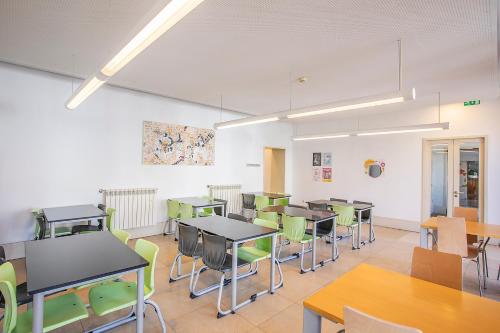 a classroom with tables and chairs in a room at HI Guimaraes - Pousada de Juventude in Guimarães