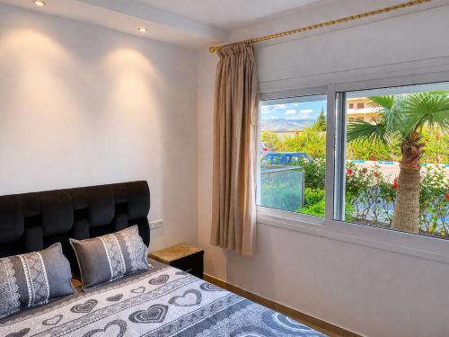 a bedroom with a bed and a large window at Appartement standing terrasse privative et piscine - Kariat Cabo in Cabo Negro