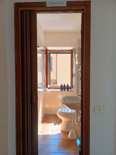a bathroom with a sink and a toilet and a window at Affascinante Mansarda nel Cuore di Brunate in Brunate