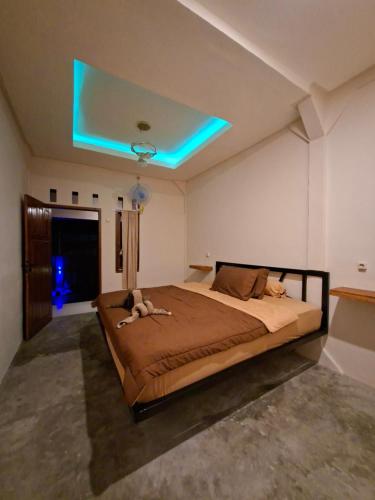a bedroom with a large bed with a blue light at Iza home stay in Senaru