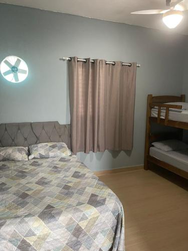 a bedroom with a bed and a window at Ape Bianck's in Ilha Comprida