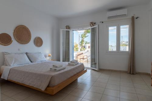 a bedroom with a large bed and a balcony at Kastro Antiparos in Antiparos