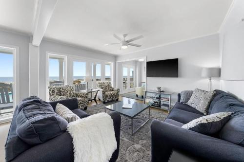 a living room with two couches and a table at SEA2SKY Ocean front private pool and spa in Kure Beach