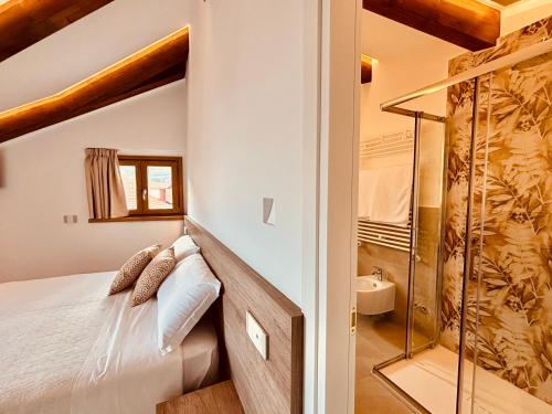 a bedroom with a bed and a glass shower at Le Perseidi in Agerola