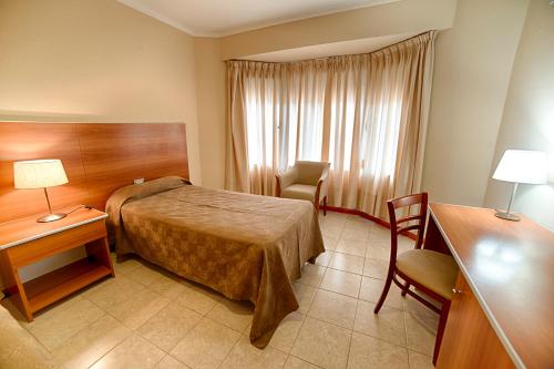 a hotel room with a bed and a table and chairs at Hotel Sol del Añelo in Añelo