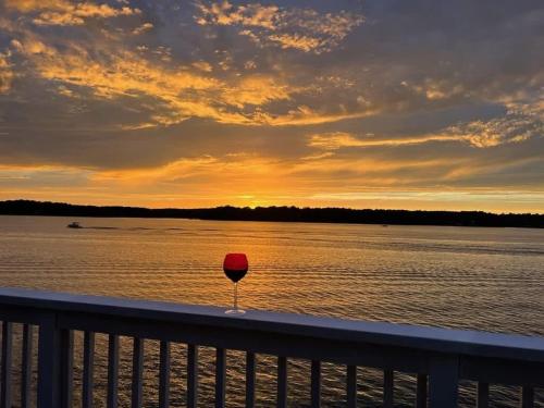 a red wine glass sitting on a railing next to the water at Wake N Lake in Littleton