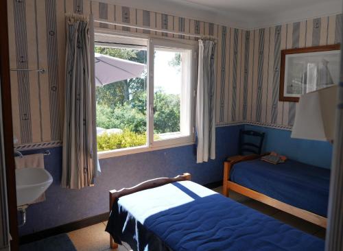 a bedroom with a bed and a sink and a window at Maison vue mer exceptionnelle in Le Lavandou
