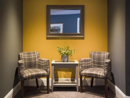 a room with two chairs and a table with a mirror at The Bridge House; BW Signature Collection in Ferndown