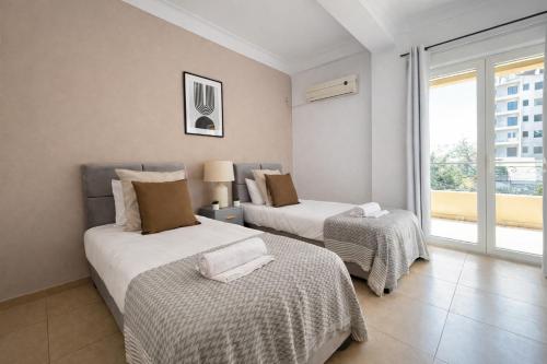 two beds in a room with a window at Magnifique appartement 3 pièces à Hydra in Hydra