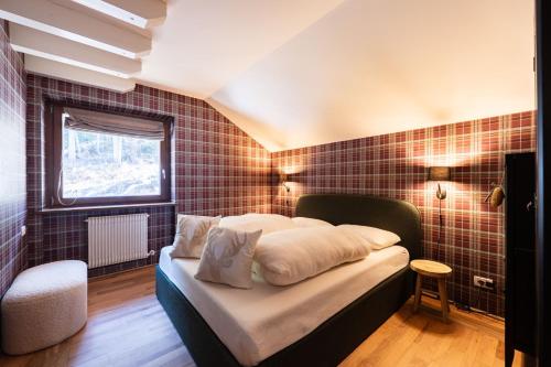 a bedroom with a bed with a tiled wall at Cesa del Volp in Canazei