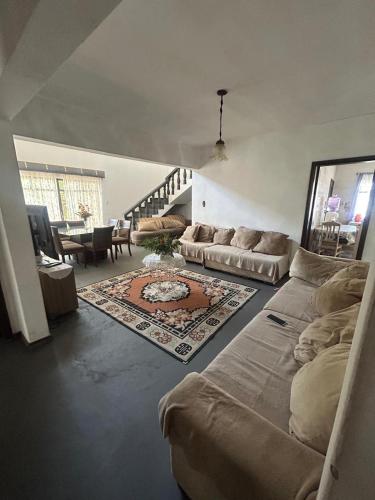 a living room with a couch and a living room with a table at Pousada Ponta Grossa in Ponta Grossa