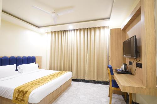 ein Hotelzimmer mit Bett und Fernseher in der Unterkunft PS Marriott Hotel in Patna