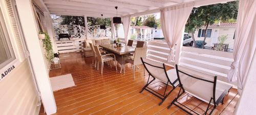 a screened in porch with a table and chairs at Mobilheim Coco in Biograd na Moru