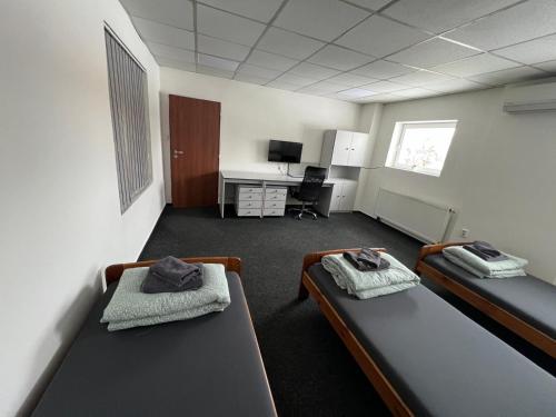 a dorm room with two beds and a desk at Apartmán Na Blatech in Česká Lípa