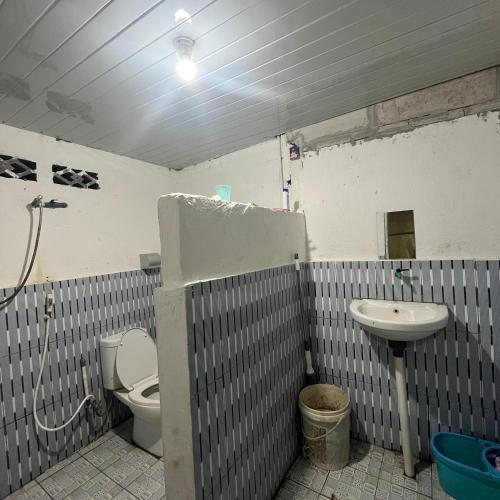 a bathroom with a toilet and a sink at RAMMANG-RAMMANG HOUSE in Maros