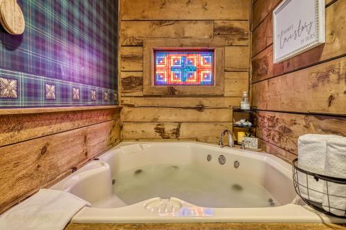 a bath tub in a bathroom with wooden walls at Honeymoon Sweet in Townsend