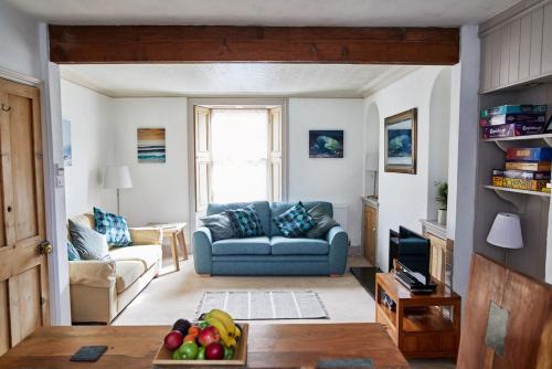 a living room with a couch and a bowl of fruit at Light and Spacious Victorian Townhouse in Central Penzance in Penzance