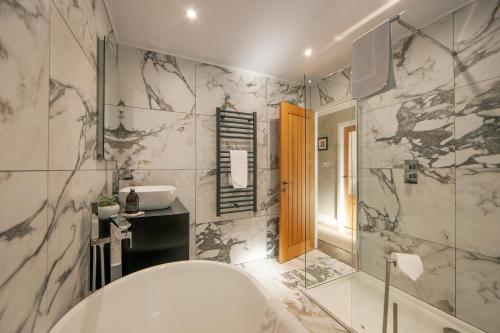 a bathroom with a tub and a sink and a shower at Cuilreigh, North Connel in Oban