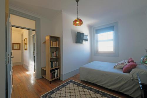a bedroom with a bed and a book shelf at Santiago de Caminha Boutique Hostel & Suites in Caminha