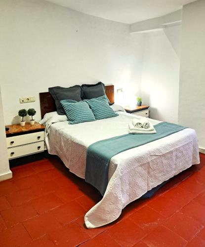 a bedroom with a large bed with blue pillows at Casa cubo in Alhama de Granada