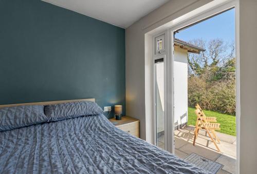 a bedroom with a bed and a sliding glass door at Landscove Chalet 19 in Brixham