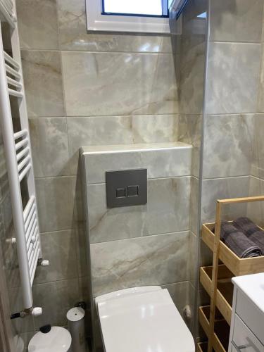ein kleines Badezimmer mit Toilette und Fenster in der Unterkunft Studio Ariadne in Thérmi