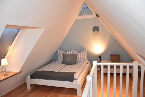 a bedroom with a bed in the attic at Dannauer Reetkate - Wiesenblick in Oldenburg in Holstein
