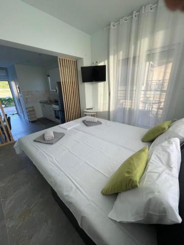 ein großes weißes Bett mit grünen Kissen in einem Zimmer in der Unterkunft Studio Ariadne in Thérmi