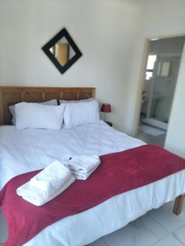 two towels on a bed with a red blanket at 15 on 11th Summerstrand in Summerstrand