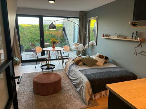 a bedroom with a bed and a table with chairs at La Rosière en Gaume in Musson