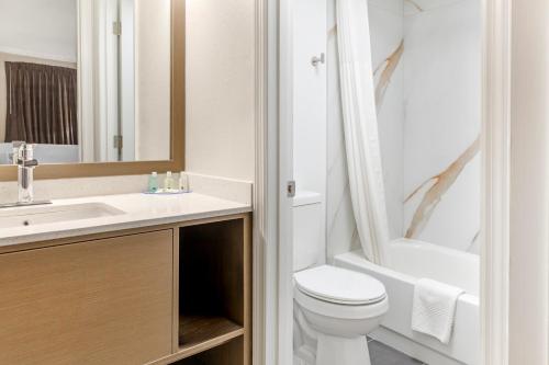 a white bathroom with a toilet and a sink at Quality Inn Findlay in Findlay