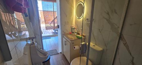 a bathroom with a toilet and a sink and a mirror at Cabaña con piscina y vista al lago in San Bernardino