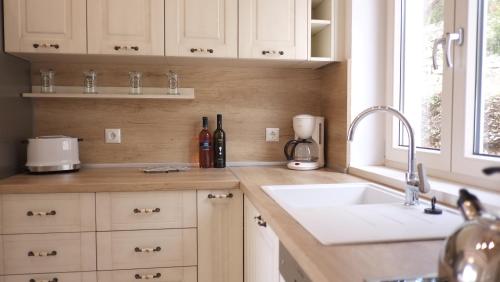 a kitchen with white cabinets and a sink and a window at Erimitis View Villa in Magaziá
