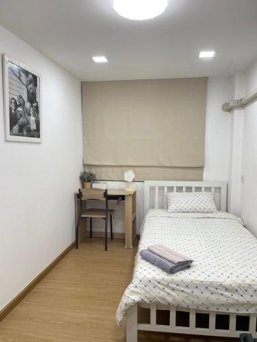 a bedroom with two beds and a desk with a table at alone happy 3 in Ban Khlong Thewa