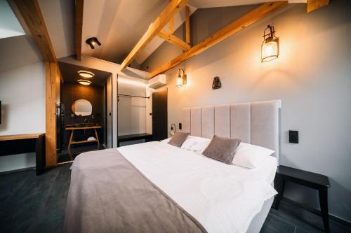 a bedroom with a large white bed and a chair at Apartmány Dačický 2 in Kutná Hora