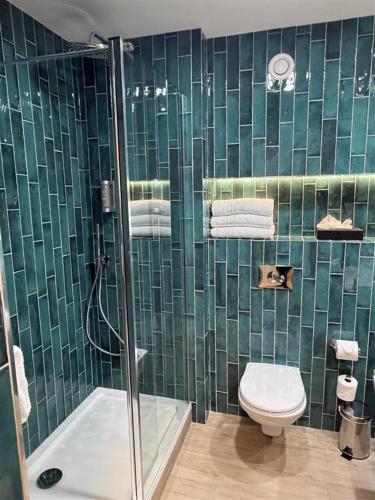 a green tiled bathroom with a toilet and a shower at Talbot Hotel Wexford in Wexford